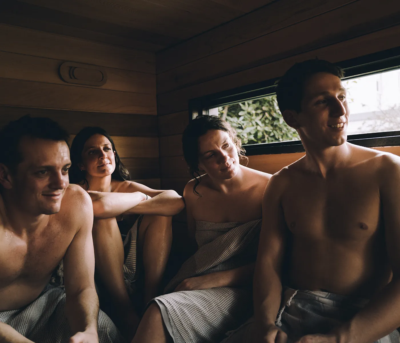 People Sitting Together Inside a Wildhut Sauna relaxing inside a Wildhut traditional wood-fired outdoor sauna